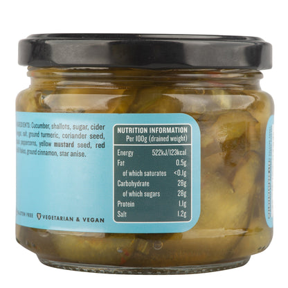 Jar of Manfood bread and butter pickles with sliced cucumbers and spices in a glass jar on a wooden surface.