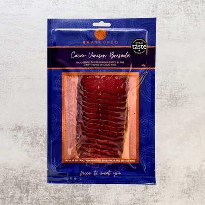 Front view of Bray Cured Cacao-Spiced Venison Bresaola, thinly sliced charcuterie with rich cacao seasoning on a white plate.
