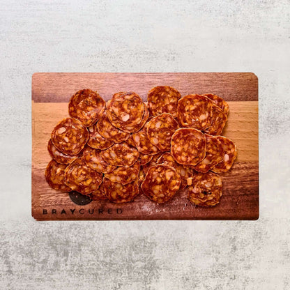 British Chorizo charcuterie board featuring sliced Bray Cured British chorizo, cheese, and accompaniments on a wooden serving platter.