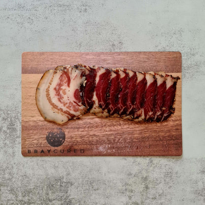 British guanciale from Bray Cured, part of the Ultimate Pasta Pack charcuterie selection, displayed on a wooden board.