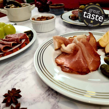 Thinly sliced British Bray Cured Classic Lomo charcuterie pork loin on a plate, showcasing its rich, cured appearance.