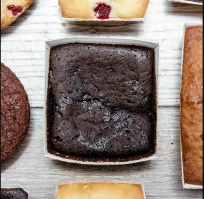 Vegan Super Dark Brownies from The Healthy Cake Company, showing a close-up of rich, dark chocolate brownies on a plate.