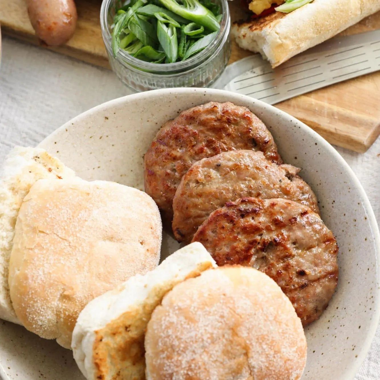 Raw pork and apple burgers from Primrose Herd, served in buns, ready for cooking.