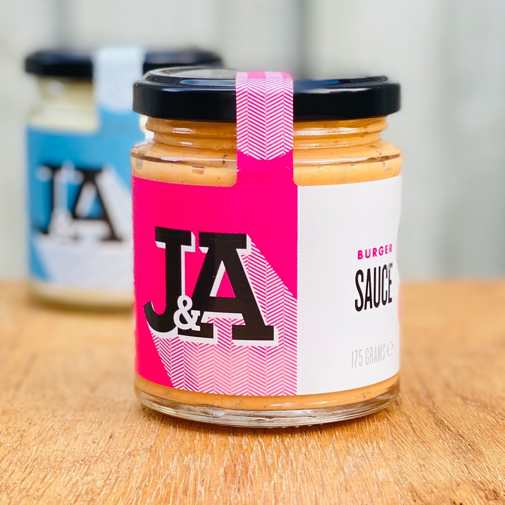 Janda burger sauce in a jar, creamy and flavorful condiment for burgers, with a smooth, rich texture and golden color.