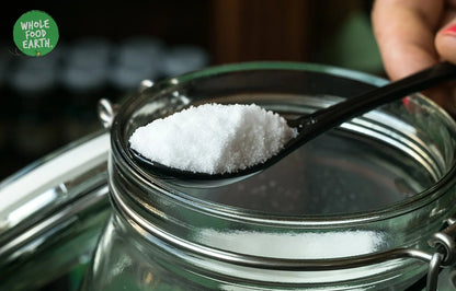 Crystalline fine sea salt from Whole Food Earth, showing textured white mineral salt crystals in a clear container.