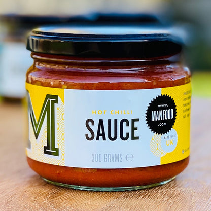 Manfood chilli sauce in a glass bottle, showcasing vibrant red chili peppers and sauce inside.
