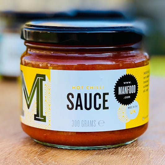 Manfood chilli sauce in a glass bottle, showcasing vibrant red chili peppers and sauce inside.