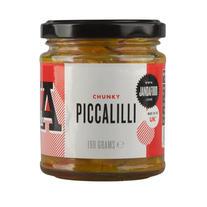 Jar of Janda chunky piccalilli with large vegetable chunks and vibrant yellow mustard seed sauce on a white background.