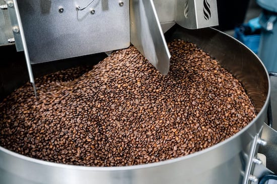 Coffee beans cooling on a tray from Clubhouse Roastery's Brook Blend Dark Roast coffee, ready for packaging or brewing.
