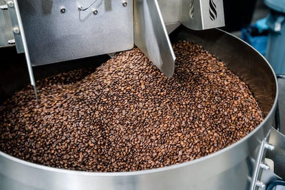 Coffee beans cooling on a tray from Clubhouse Roastery's Brook Blend Dark Roast coffee, ready for packaging or brewing.