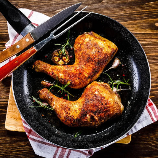 Cooked Creedy Carver free-range chicken legs from Primrose Herd, showcasing juicy, tender chicken with crispy skin.