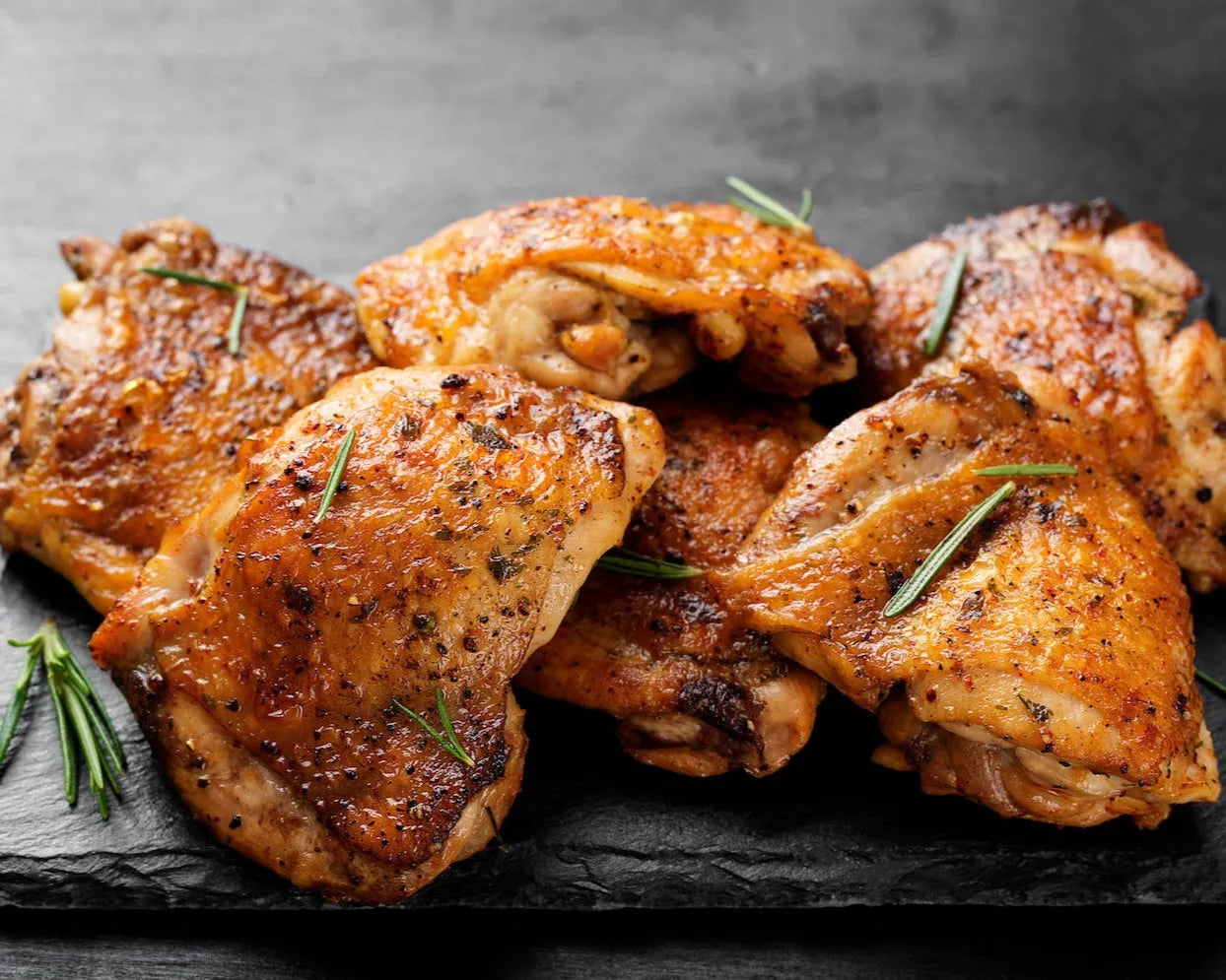 Cooked Creedy Carver free-range boneless chicken thighs from Primrose Herd, showing juicy, browned chicken thighs on a plate.