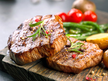 Cooked Primrose Herd filet mignon beef steak fillets on a plate, showcasing tender, perfectly cooked beef.