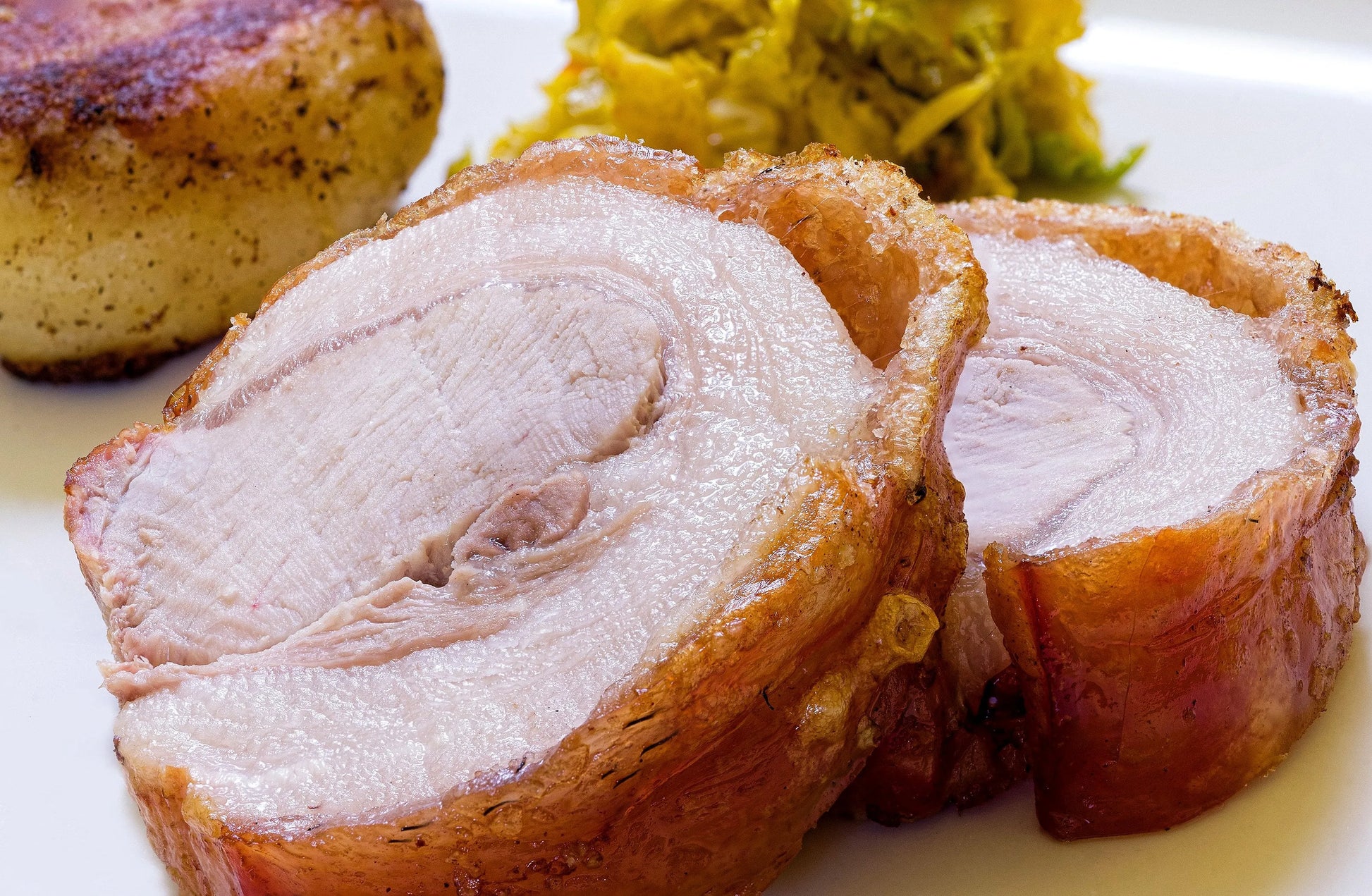 Cooked pork loin joint from Primrose Herd Half Pig Pork Box, showcasing a tender, sliced meat cut ready for serving.