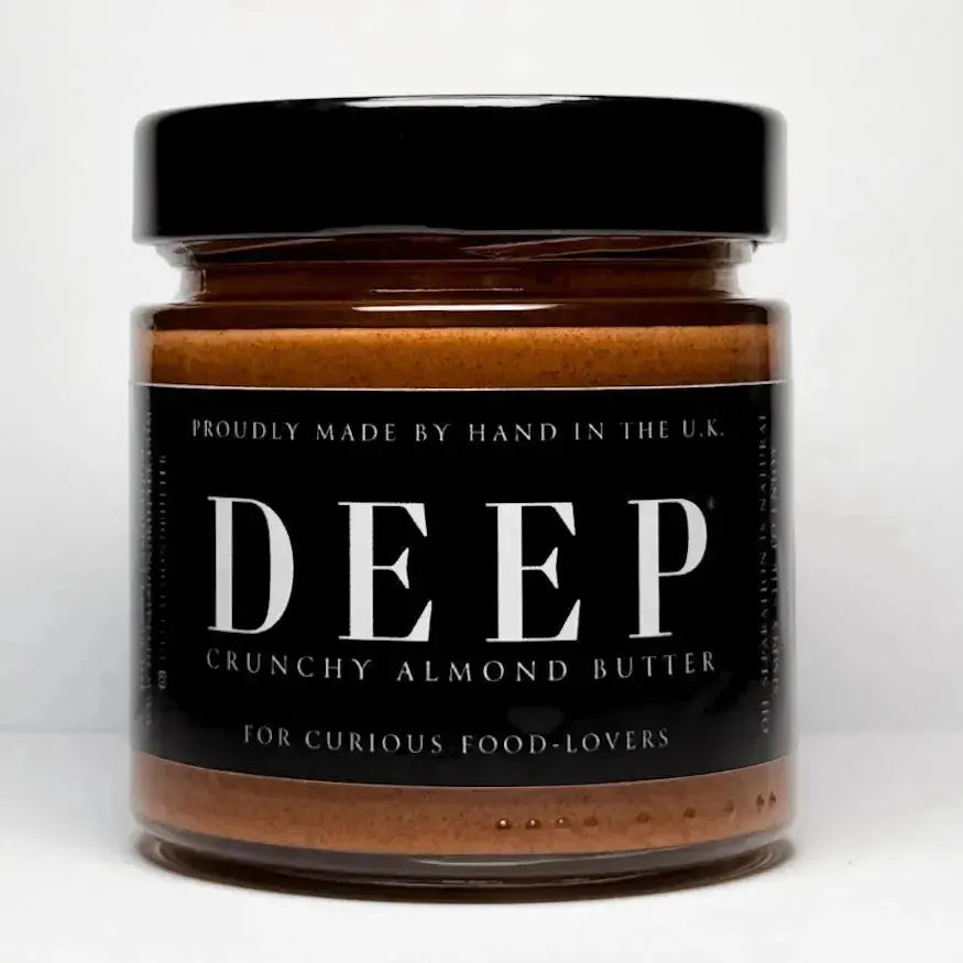 Crunchy DEEP Almond Butter jar with visible almond pieces, showcasing the nut butter's textured, crunchy surface.