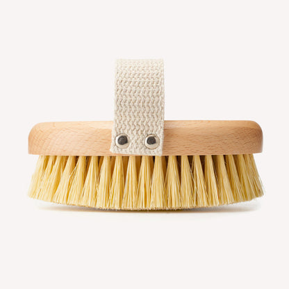 Natural bristle dry body brush from Wild And Stone, showing a wooden handle and soft bristles for exfoliating skin.
