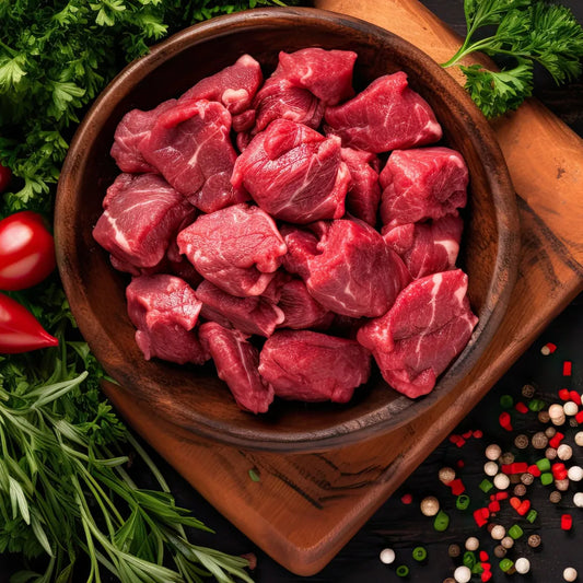Diced Primrose Herd beef showing evenly cut, fresh diced beef pieces in a clear container on a white background.