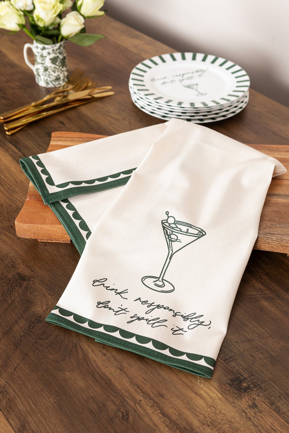 Bone china plate with "Drink Responsibly, Don't Spill" message from Avalon Home UK, displayed on a table with a tea towel nearby.