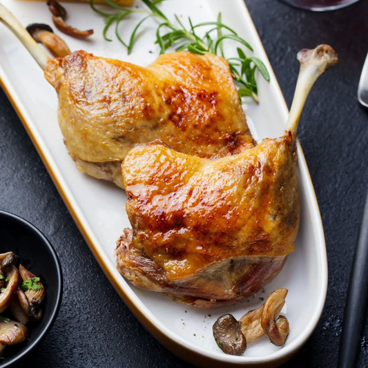 Primrose Herd Creedy Carver free-range confit duck legs showcasing golden, tender duck legs with crispy skin on a white plate.