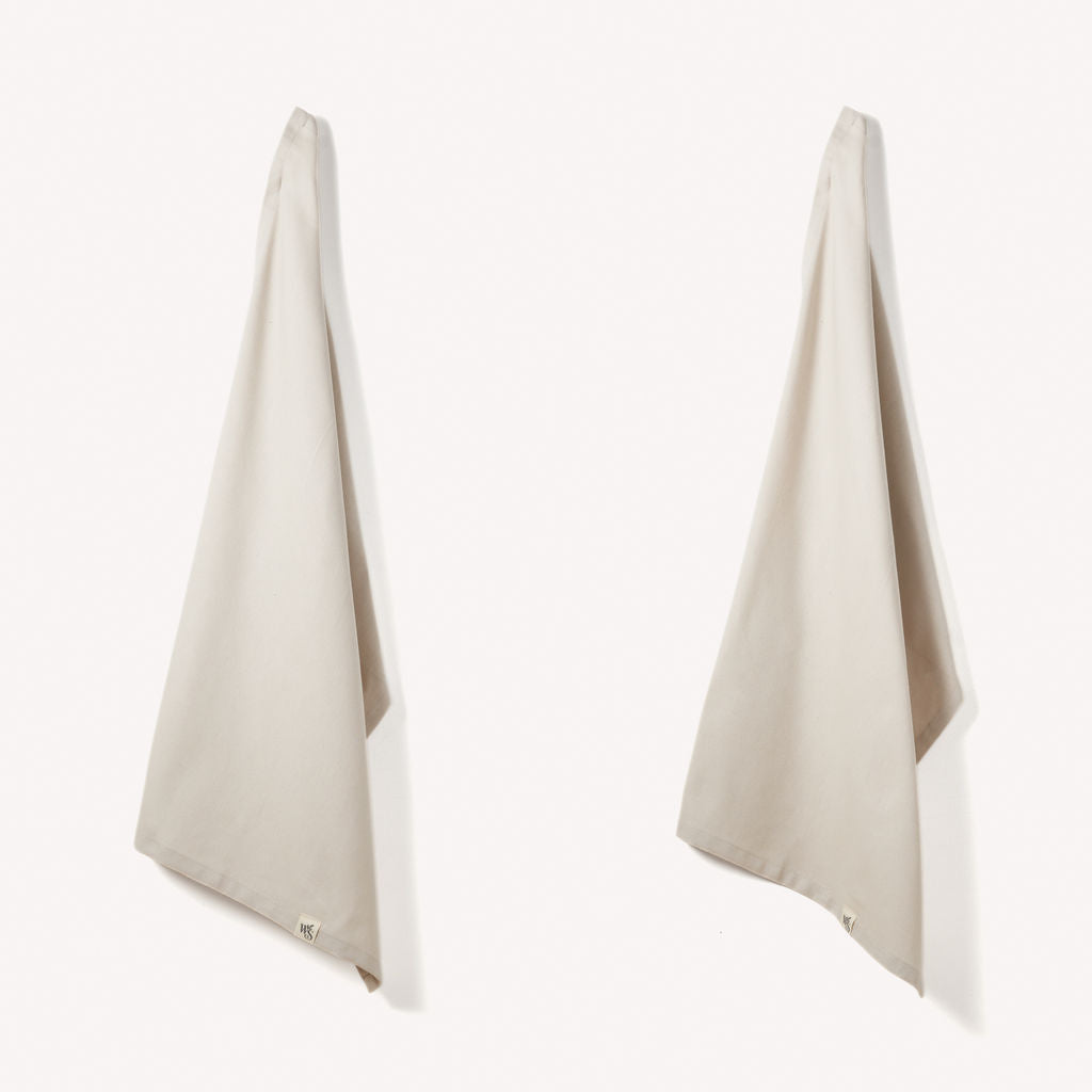 Set of 2 Wild And Stone organic cotton tea towels with herringbone weave, showcasing soft, textured fabric for kitchen use.