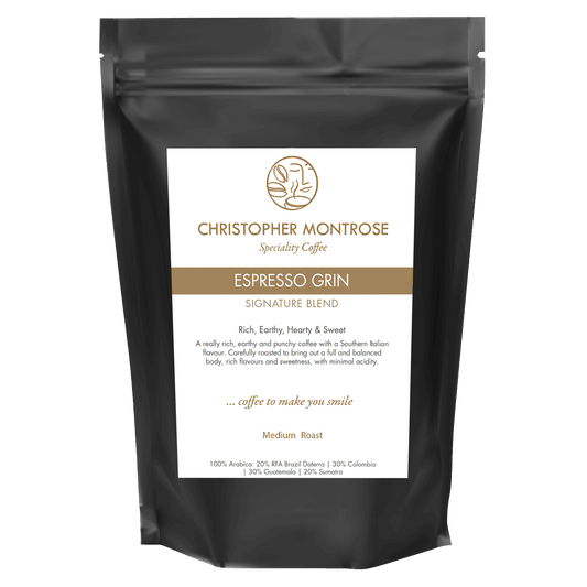 Close-up of Christopher Montrose Coffee Espresso Grin Arabica Coffee Beans in a clear container, showcasing rich, dark roasted beans.