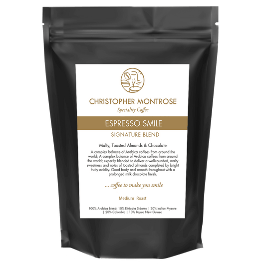 Close-up of Christopher Montrose Coffee Arabica Espresso Smile coffee beans in a transparent bag with a visible label.