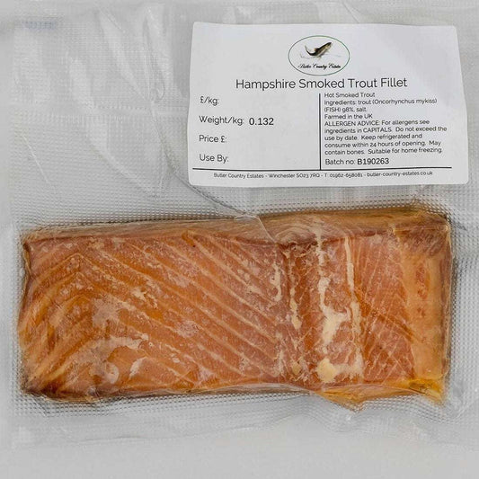 Smoked trout fillets from Hampshire, served on a plate with lemon slices and fresh herbs, by Butler Country Estates.
