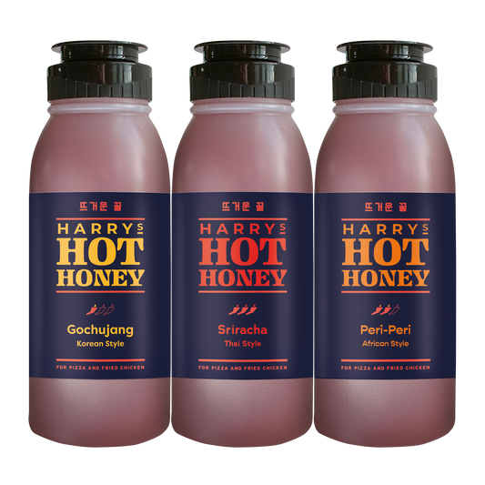 Three Harry's Hot Honey fusion sauces in gochujang, sriracha, and Thai flavors in glass bottles on a white background.