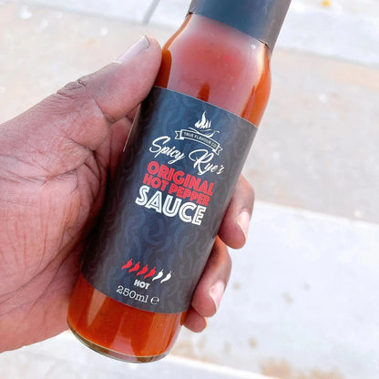 Spicy Ryes Original Hot Pepper Sauce bottle with bright red chili peppers and hot sauce pouring from the bottle.