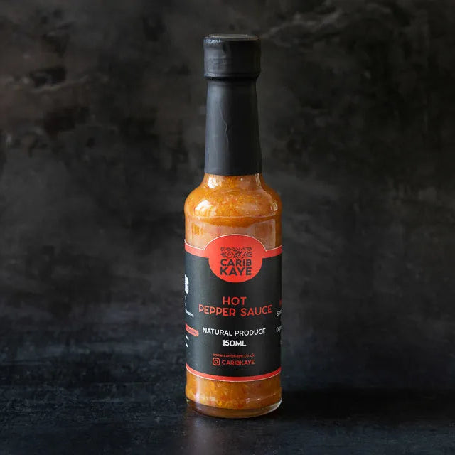 CaribKaye Hot Pepper Sauce bottle with bright red hot sauce, featuring a label and cap, on a neutral background.