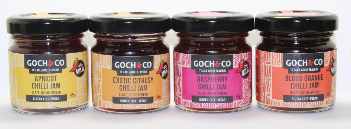 Assorted sweet and savory chilli jams in four 45g jars from Goch & Co, arranged in a gift set.