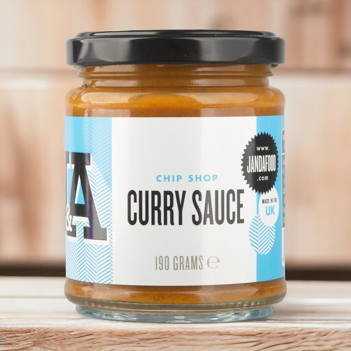 Jar of Janda Chip Shop Curry Sauce with label visible, showcasing the rich, golden curry sauce inside the jar.