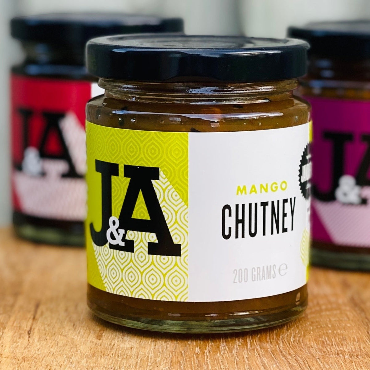 J&A Mango Chutney jar showing rich, golden mango chutney with a label, ideal for pairing with Indian dishes.