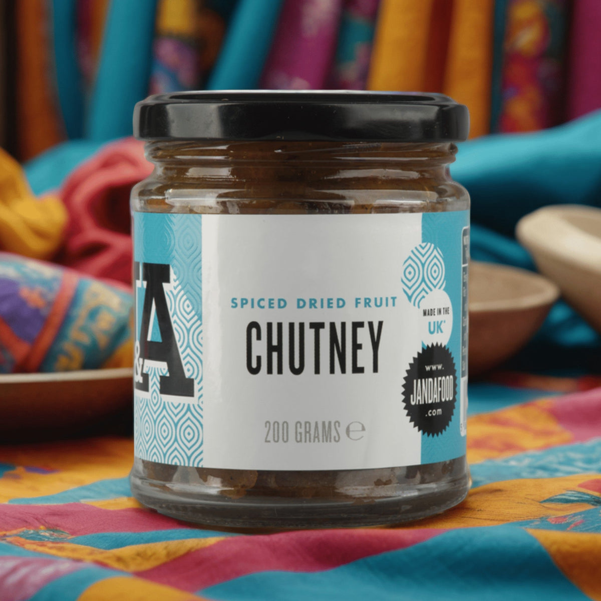 Jar of Janda dried fruit chutney with visible spices and dried fruit pieces in a glass jar on a white background.