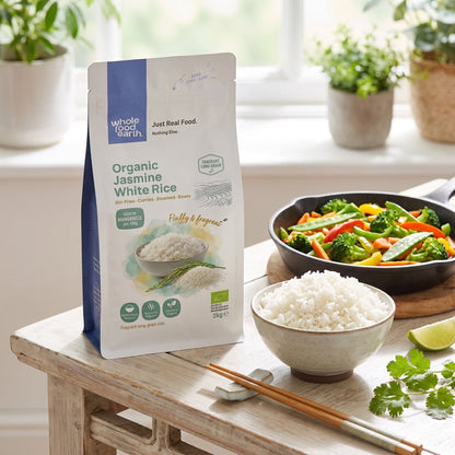Organic Jasmine White Rice from Whole Food Earth, showcasing a bowl of cooked jasmine rice with fresh herbs and a spoon.