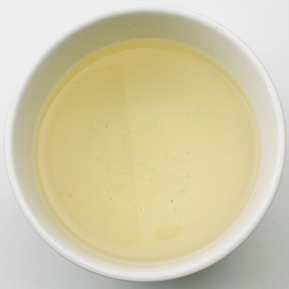 Bright image of Jasmine Dragon Pearl Green Tea liquor in a glass cup, highlighting the delicate, fragrant green tea pearls.