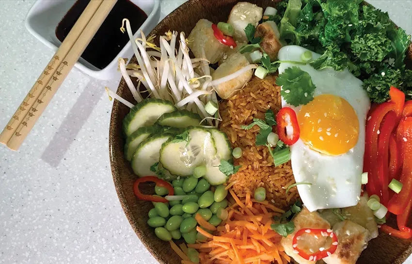 Small bowl of Korean bibimbap with Taishon vegan sweet and spicy sauce, showcasing vibrant vegetables and rice.