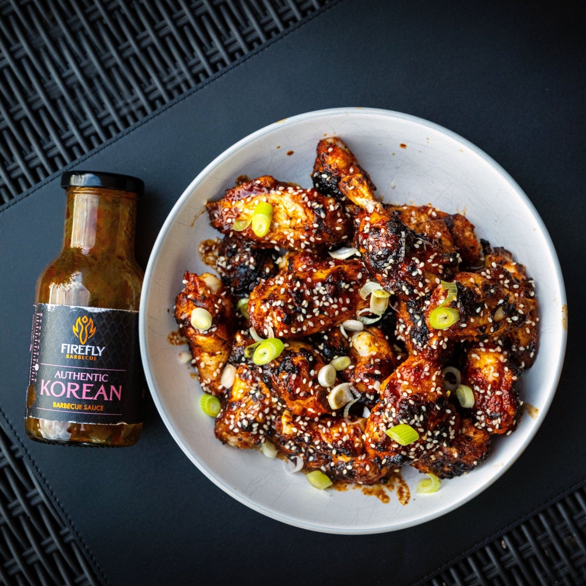 FireFly Barbecue Korean BBQ sauce glazed chicken wings on a plate, showcasing the glossy, flavorful Korean-inspired sauce.