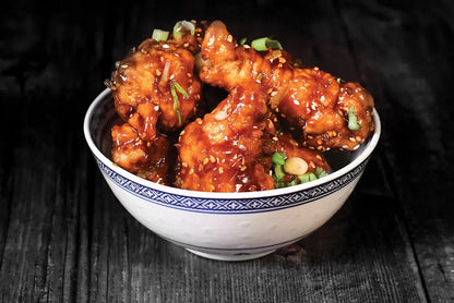Three bottles of Taishon Peking Sweet and Savoury Vegan Sauce for cooking and marinades, shown with Korean chicken wings.