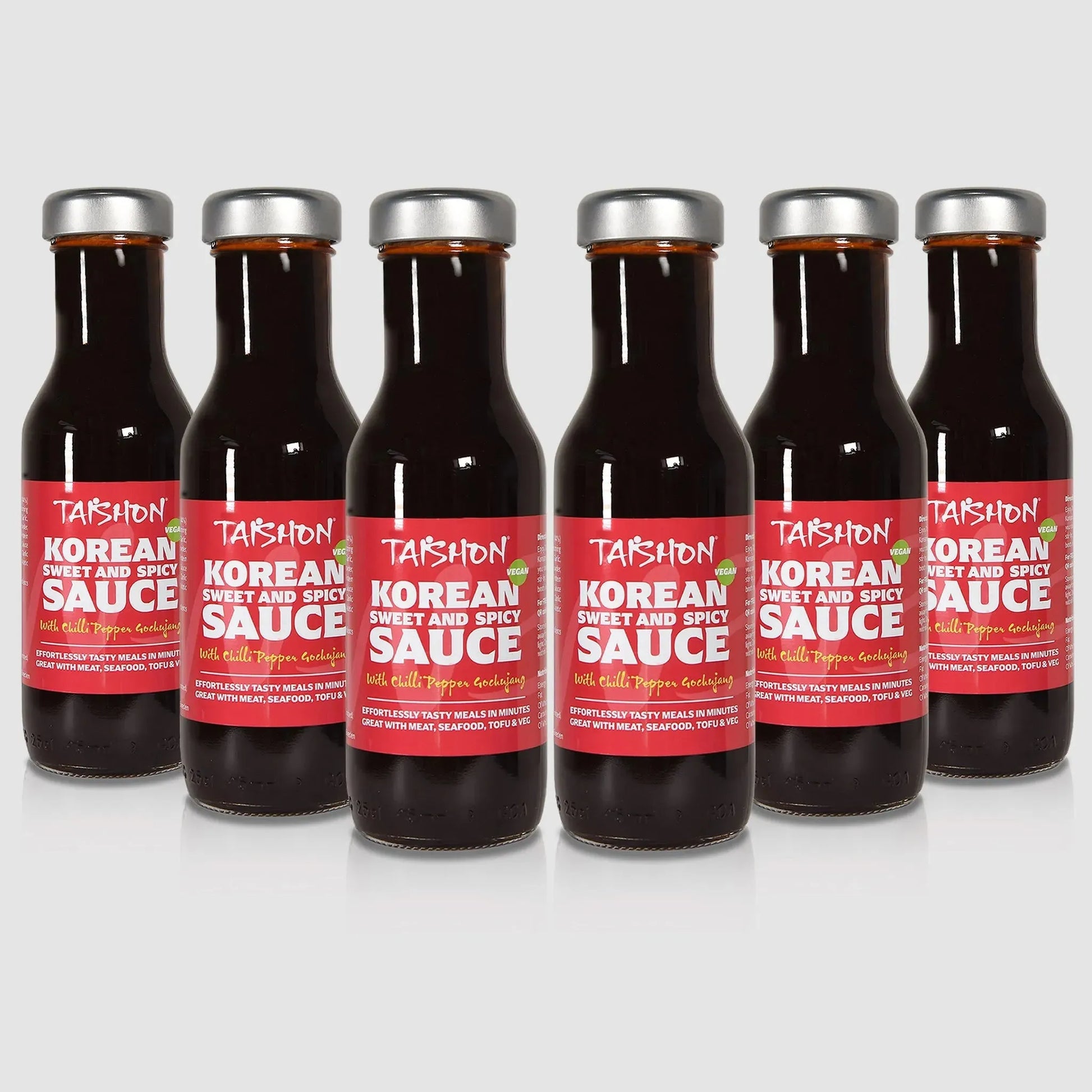 Six bottles of Taishon Korean sweet and spicy vegan sauce, showcasing vibrant label and bottles in a case for cooking and marinating.