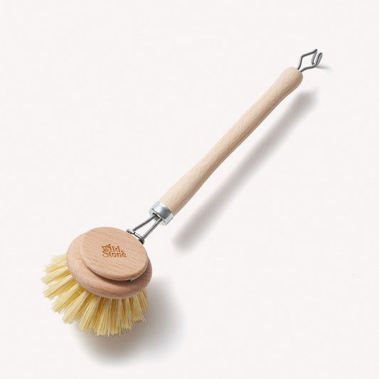 Wooden dish brush with replaceable head by Wild And Stone, showing the natural wood handle and cleaning bristles.