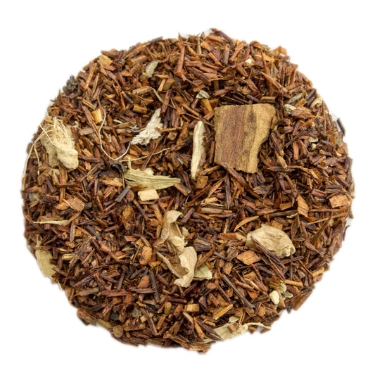 PekoeTea Edinburgh chai rooibos tea with masala spices in a clear glass cup, showcasing rich reddish-brown herbal tea.
