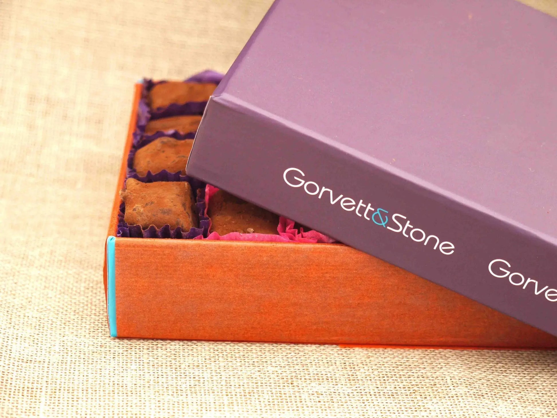 Box of Gorvett & Stone milk chocolate truffles with sea salt, showcasing glossy chocolates with a hint of sea salt on top.