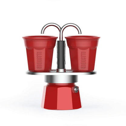 Red Bialetti Mini Express 'R' double serve espresso maker with two cups for brewing authentic Italian coffee.