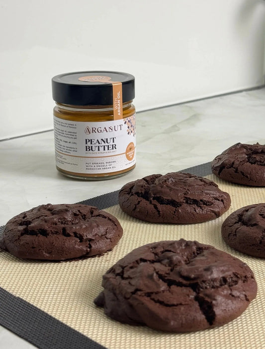 Smooth ArgaNut nut butter with peanut, argan oil, and date syrup in a 200g jar, shown with a spoon and spread on bread.