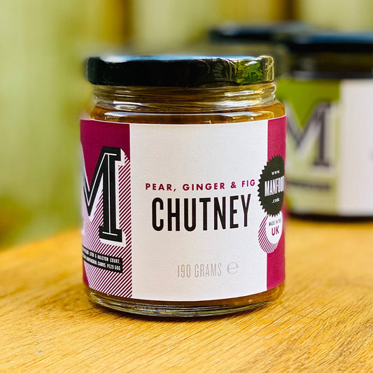 Manfood pear, apple, fig, and plum chutney in a jar, showcasing a colorful, chunky fruit mixture with a rustic label.