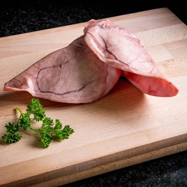 Fresh pig ears from Primrose Herd, natural offal treats for dogs, showing whole pig ears on a white background.