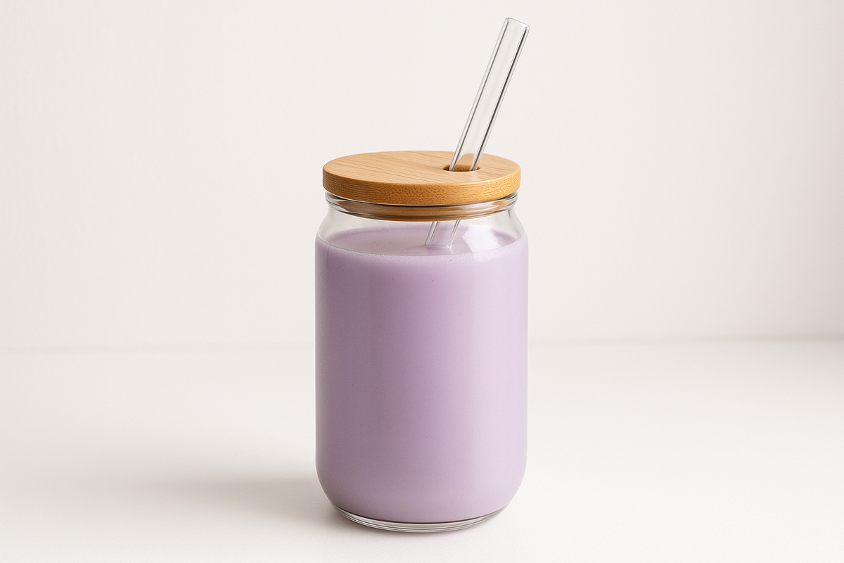 Purple Ube protein drink by Siocolat in a glass with a frothy top, showcasing vibrant purple color and creamy texture.