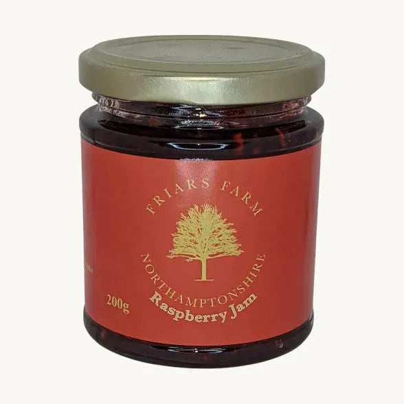 Traditional Raspberry Jam by Friars Farm in a clear jar with a vibrant red raspberry jam visible on the front.