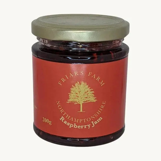Traditional Raspberry Jam by Friars Farm in a clear jar with a vibrant red raspberry jam visible on the front.